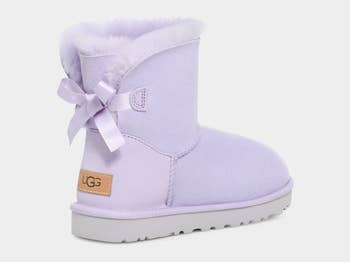 the back of the lavender colored boots with bows on them