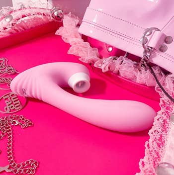 Pink dual-stimulating vibrator surrounded by pink items