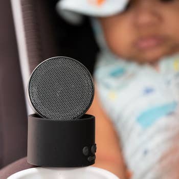 Portable achromatic  talker  successful  absorption   with a blurred babe  successful  the background, showcasing parenting-friendly tech products