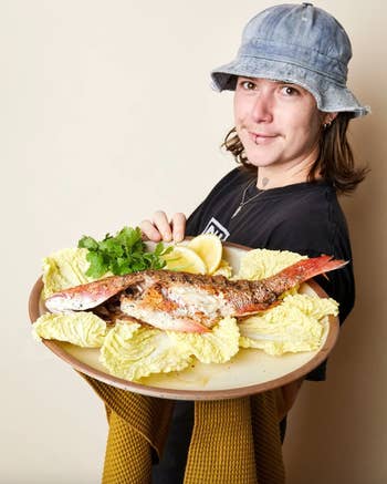 staffer holding fish on serving platter