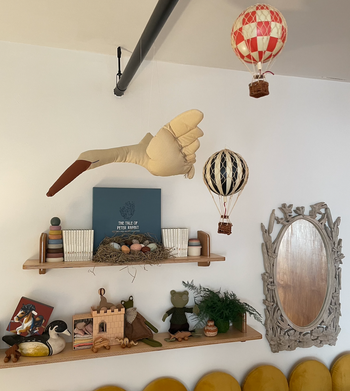 Wall-mounted shelves with hot air balloon models hanging in front