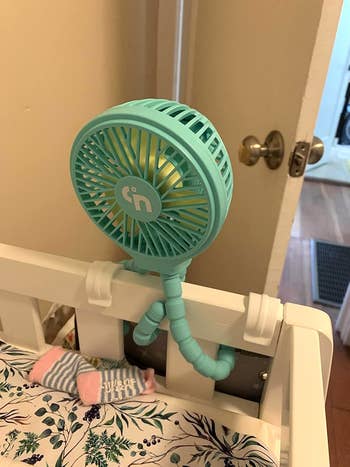 Portable clip-on instrumentality   attached to crib, with flexible tripod legs. Baby socks disposable   below. Perfect for keeping infants chill  and comfortable