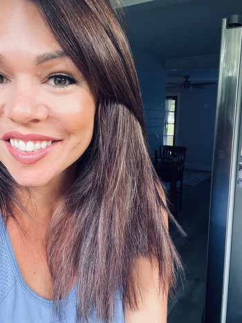 Reviewer with brown shiny hair with a blue top