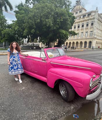 writer in another printed dress beside a vintage car