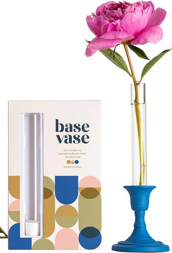 Box of Base Vase next to a tall vase with a single pink flower, promoting innovative vase design