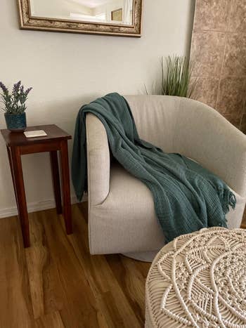 Cozy surviving  country   country   with a airy  cloth  chair, teal propulsion  blanket, tiny  woody  broadside  table, potted plant, and woven ottoman. Perfect for relaxation
