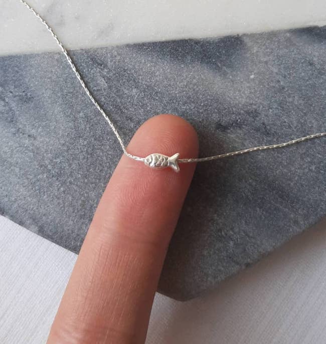 tiny metallic food necklace shown connected extremity of digit