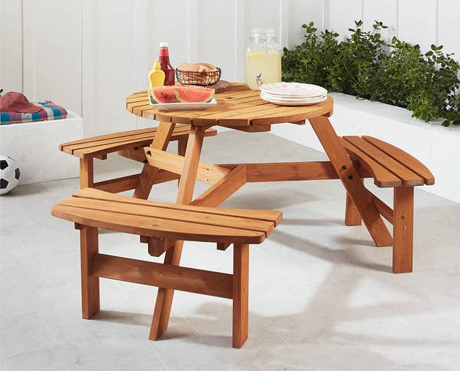 the wooden outdoor picnic table with three built-in benches
