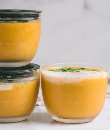 Closeup of cup-shaped glass prep bowl with soup in it and measurements on the side 
