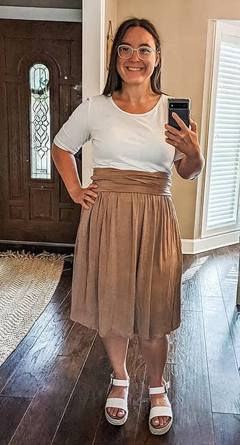 Reviewer wearing taupe skirt and white top