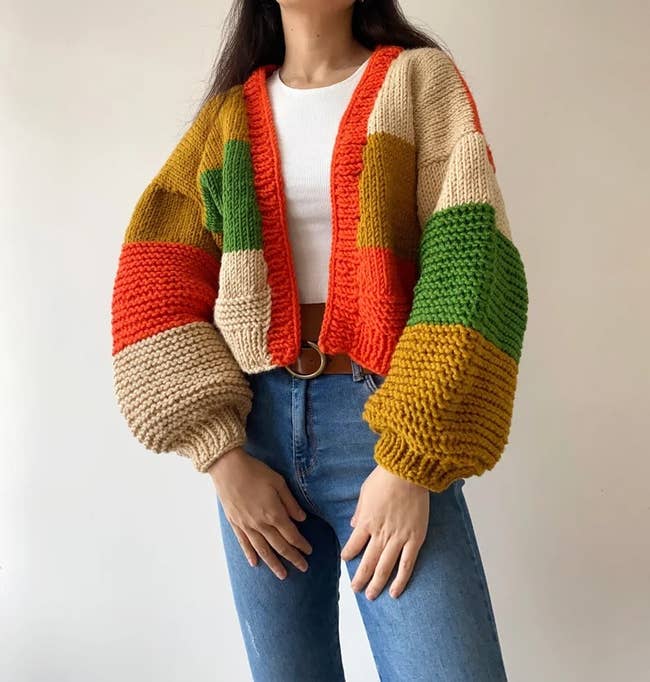 a model wearing the orange, yellow, and green patchwork cardigan