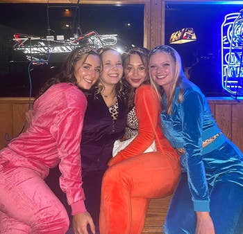 four reviewers wearing the velour tracksuit in different colors