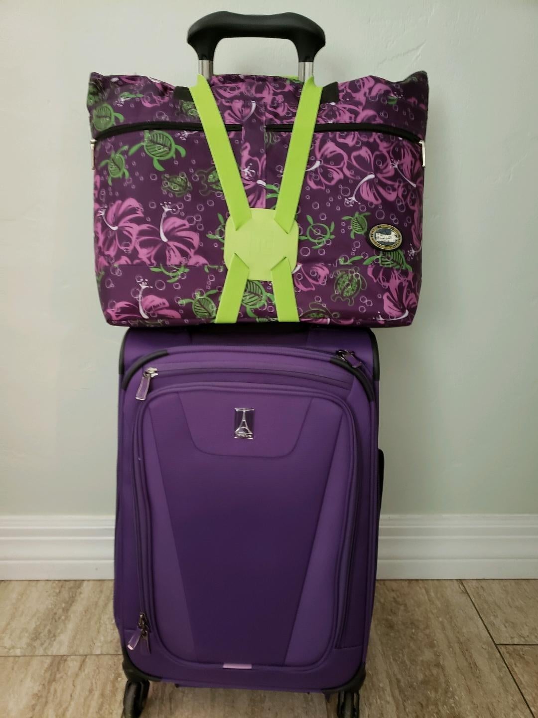 Reviewer photo of the lime green bungee cord holding a bag on top of a luggage