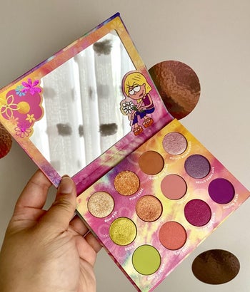 a buzzfeed editor holding the palette that has a cartoon lizzie next to the mirror