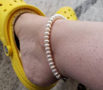 Reviewer wearing pearl anklet with yellow shoes
