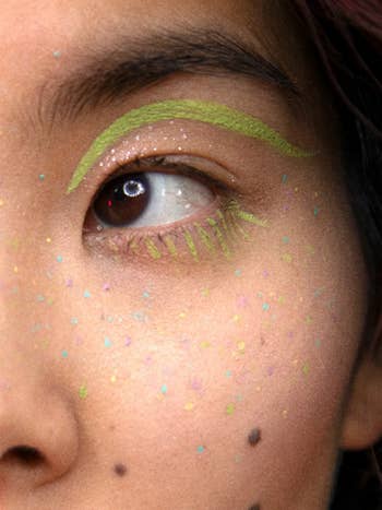 model wears green liquid eyeshadow