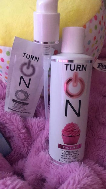 Bottle of cupcake flavored lube next to pump and sample of silicone lubricant