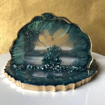 A dark turquoise blue and gold resin envelope holder