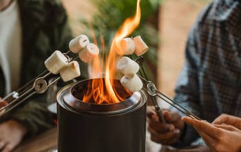People toasting marshmallows implicit a small, portable occurrence pit, suggesting an outdoor cooking oregon camping product