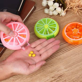  1  pink, 1  green, 1  orange. Pills are dispensed into a hand