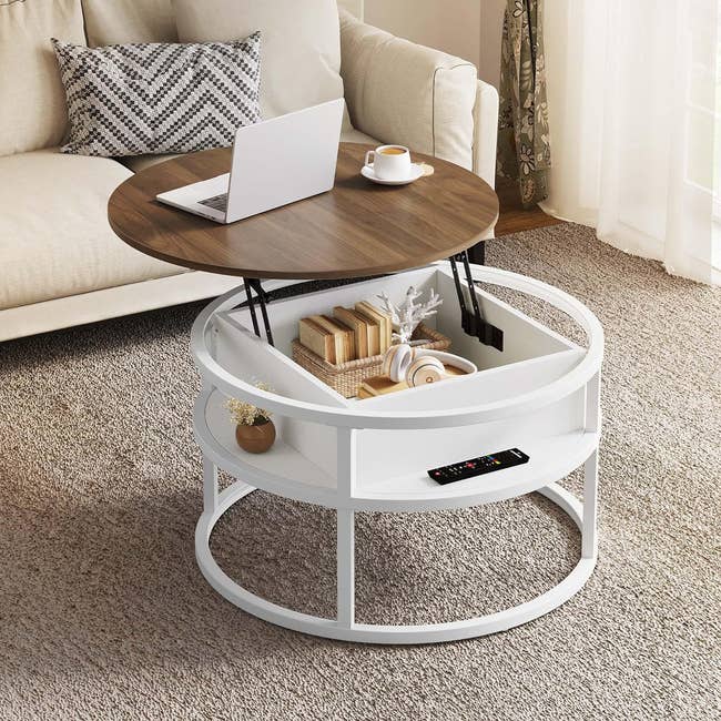 Round white coffee table with storage, laptop on top, in a cozy living room setting