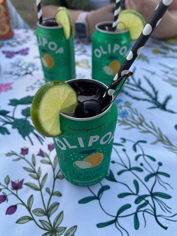 reviewer's opless Olipop lemon-lime soda cans with straws and lime slices
