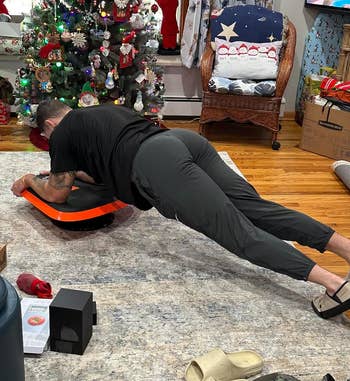 a reviewer doing a plank with the halfway trainer