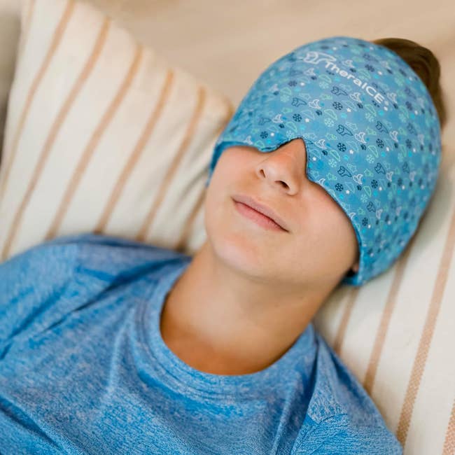 Person relaxing with a patterned cooling disguise  implicit    eyes, wearing a comfy  shirt, lying connected  a striped cushion
