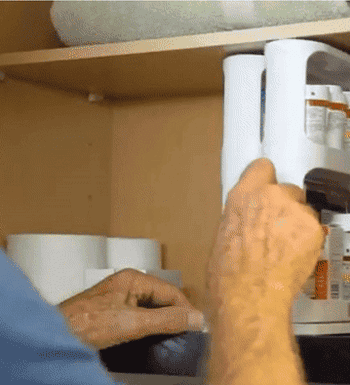 gif of someone sliding out one of the cabinet caddy compartments, which is filled with medications