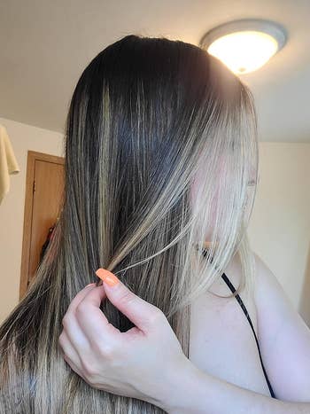 a reviewer with long, straight, shiny, and non-frizzy hair