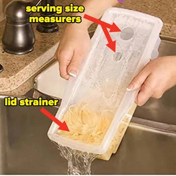 The clear rectangular container with pasta in it with the water being poured out