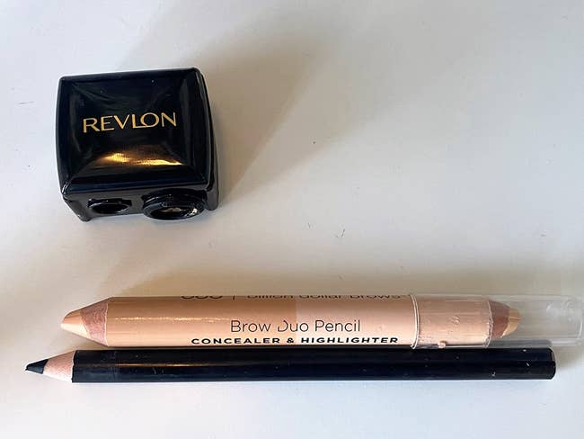 A thin eyeliner pencil and a jumbo concealer pencil both sharpened by the Revlon Dual Sharpener