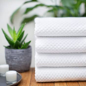 the four white waffle weave towels folded up in a pile