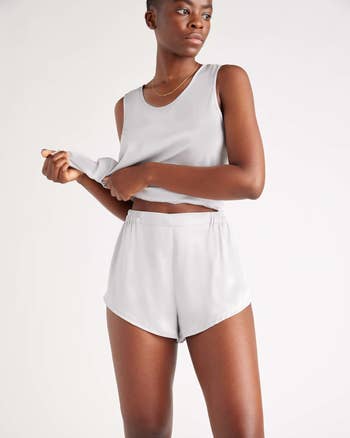 Person models a minimalist, sleeveless apical and shorts set