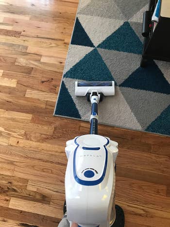 a reviewer using the vacuum on a carpet