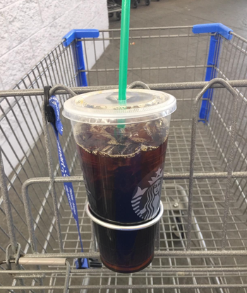 A starbucks cup attached to a metal cart 