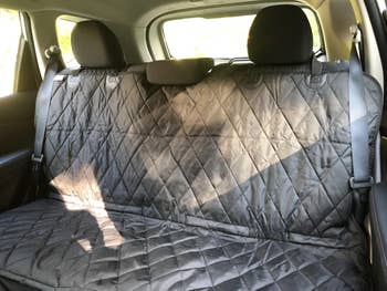 Car seat cover on rear bench in a vehicle, suitable for pet owners to protect upholstery while shopping