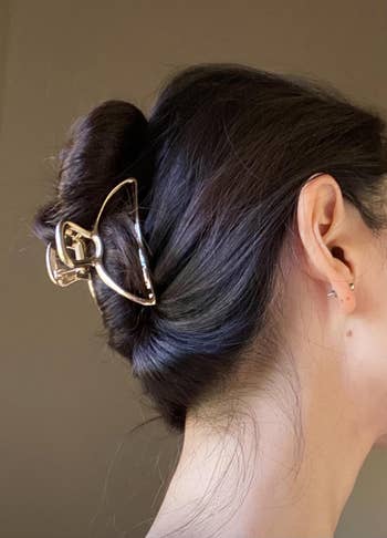 Profile view of a person with a gold hair claw clip
