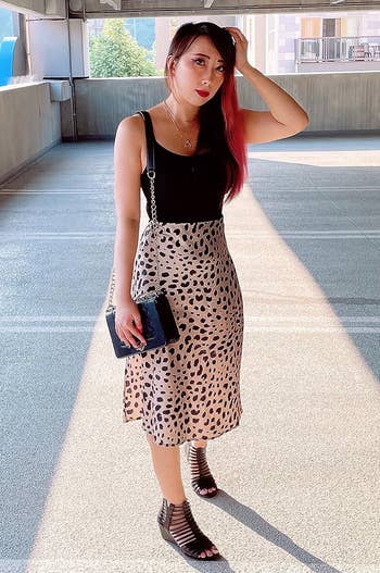 reviewer wearing the leopard print skirt