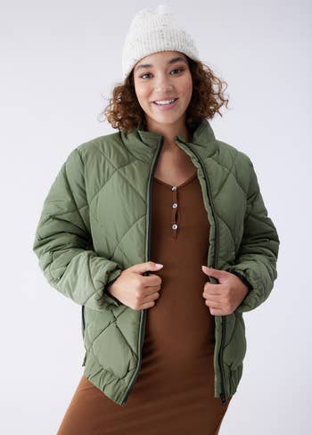 a pregnant model in a green quilted coat