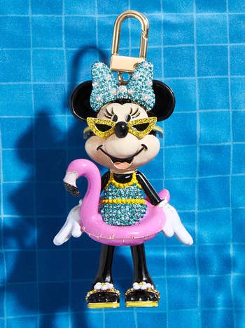 a minnie mouse enamel keychain of minnie in a bathing suit with a flamingo tube
