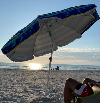 Reviewer image of the blue umbrella at sunset on a beach
