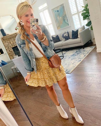 Reviewer is wearing a white top, denim jacket, and a yellow tiered mini skirt