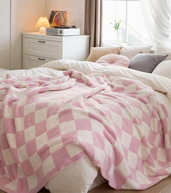 pink checkered blanket draped on a bed