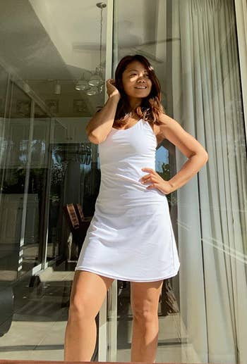 Reviewer in white strappy mid length athletic dress 