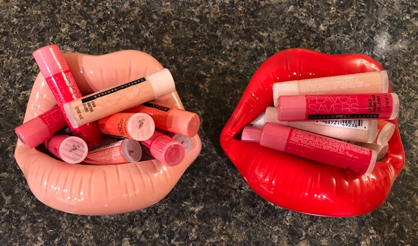 Two lip-shaped containers in pink and red with lip balms stashed inside of them 