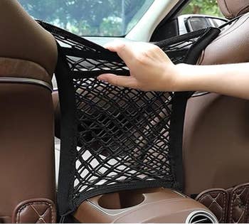 Hand pressing on mesh suspended between seats 