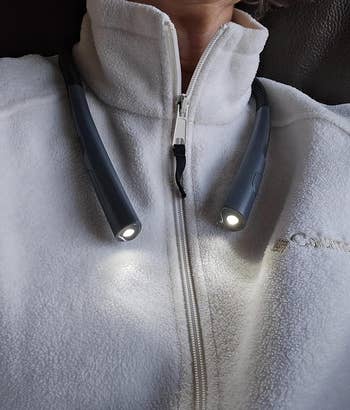 Person wearing a airy grey fleece with a neck-worn speechmaking light, showcasing a cozy and functional accessory for speechmaking oregon tasks