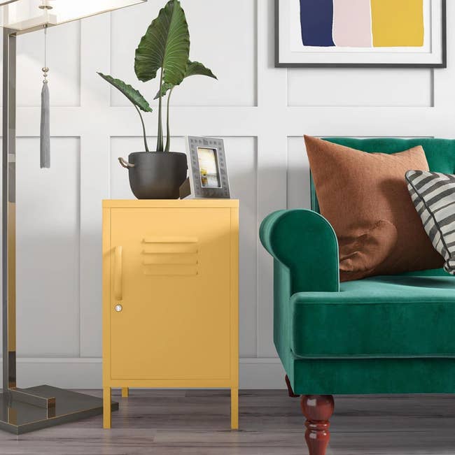 the yellow locker end table next to a couch with a picture frame and plant on top