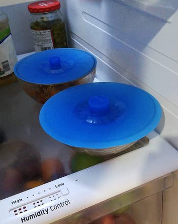 a reviewer photo of two bowls in a fridge with silicone lids on each 